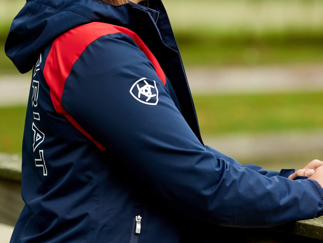 Ariat Women's Spectator Waterproof Jacket in Team Navy with Red and a hood is attached